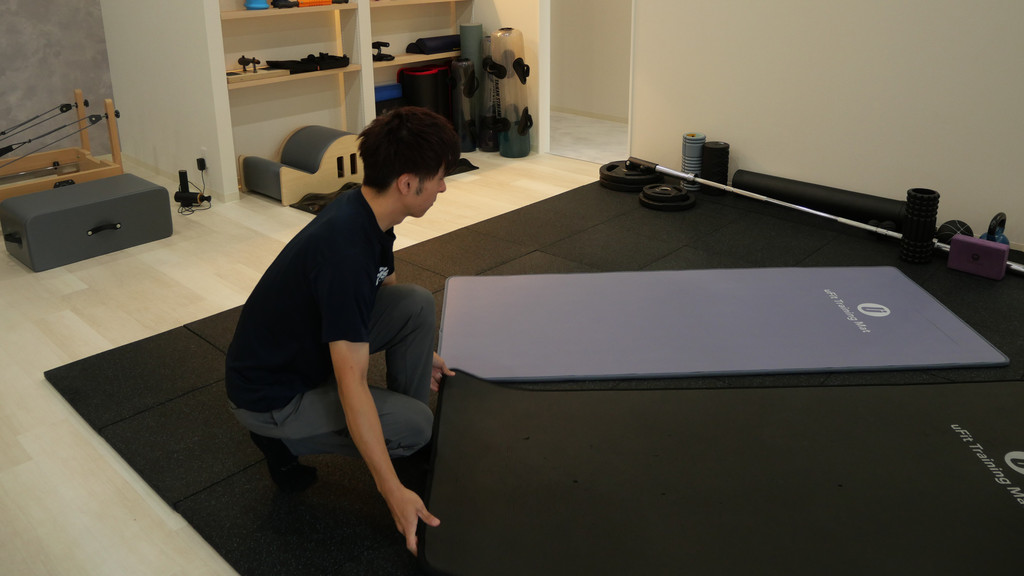 パーソナルトレーニングスタジオVisionでマットを用意する福島さん
